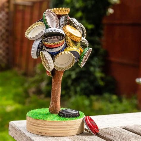 Un arbre en bois avec une bille magnétique centrale entourée de capsules de bière métalliques colorées