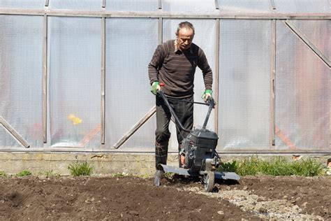 Photographie d'un jardinier utilisant une motobineuse avec un équipement de protection complet