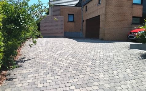 Photo d'un jardinier utilisant une lance thermique sur une allée pavée