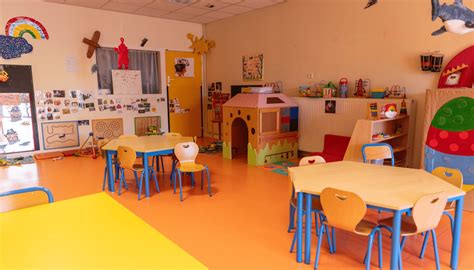 Enfants en classe de maternelle manipulant de la terre et des outils de jardinage pour planter des bulbes