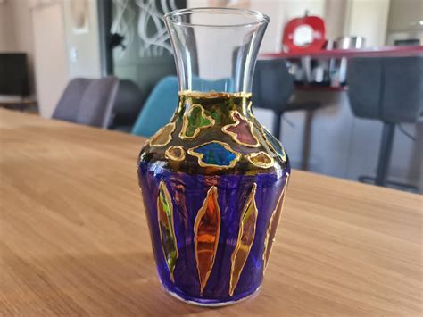 un vase en verre décoré de motifs abstraits colorés réalisés avec des marqueurs Posca