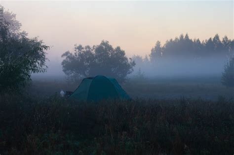 Tente au bord d'une rivière au lever du soleil
