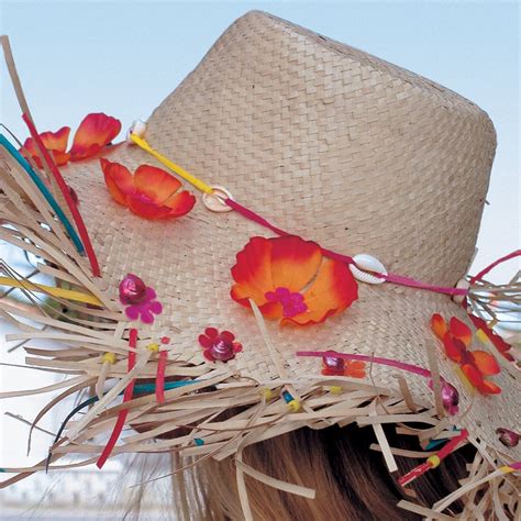 Enfant portant un chapeau de paille décoré avec des fleurs en tissu dans un jardin