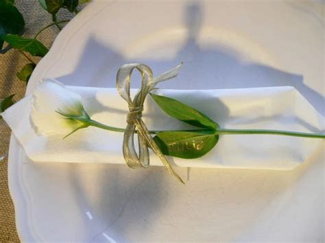 marque-place en lisianthus et ruban doré sur serviette