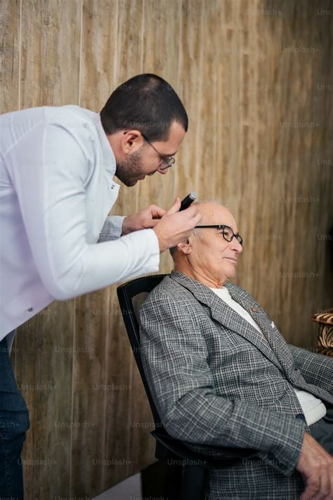 Un homme souriant se faisant couper les cheveux chez le coiffeur
