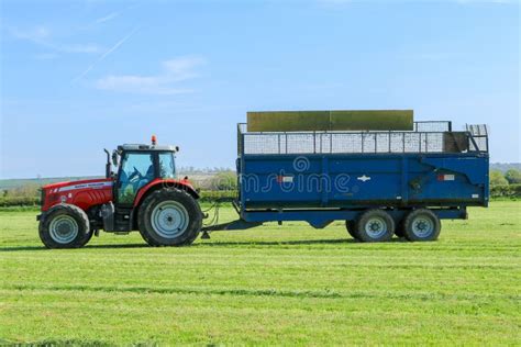 Tracteur de pelouse tirant une remorque de jardin remplie de bois