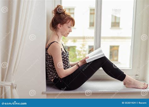 Femme lisant un livre sur les plantes dans un jardin