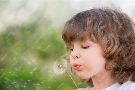 Image d'un enfant soufflant sur un pissenlit