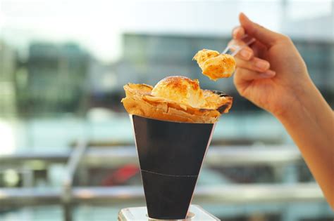 Personne mangeant une crêpe dans un cornet en bagasse