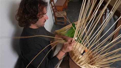 Artisan vannier tressant un panier en osier