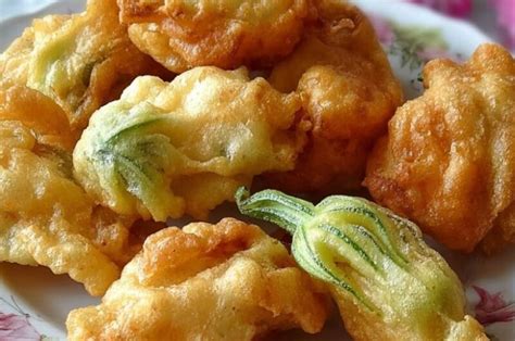 assiette de beignets de fleurs de courgettes dorés accompagnés d'une sauce légère
