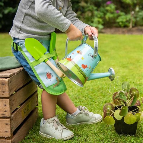 Enfant riant en jardinant avec un arrosoir