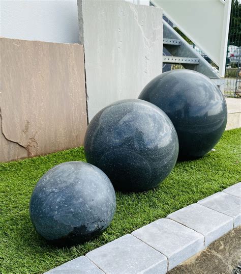 Boules décoratives en granit dans un massif de gravier