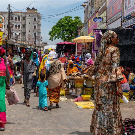 Photo de rue à Dakar montrant des vendeurs de boissons artisanales avec des bouteilles de bissap