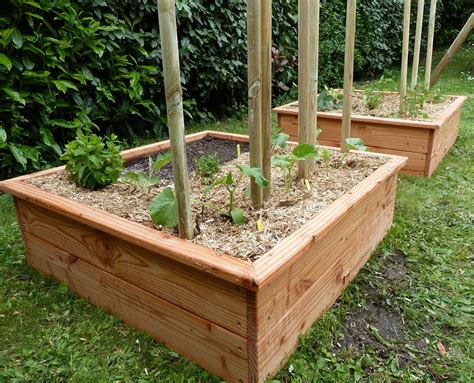 Photo montrant des carrés potagers en bois disposés sur une terrasse ensoleillée