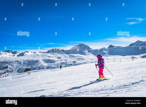 Fille en tenue de ski souriante sur une piste ensoleillée