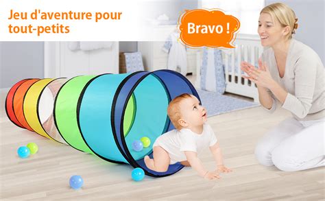 Enfant rampant sous un tunnel improvisé avec des chaises et un drap