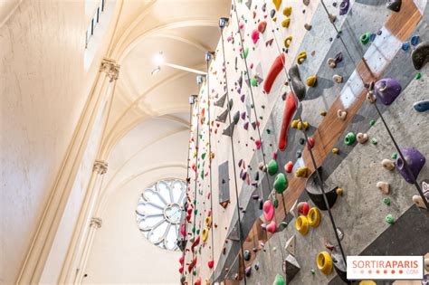 un grimpeur concentré sur un bloc dans une salle d'escalade moderne