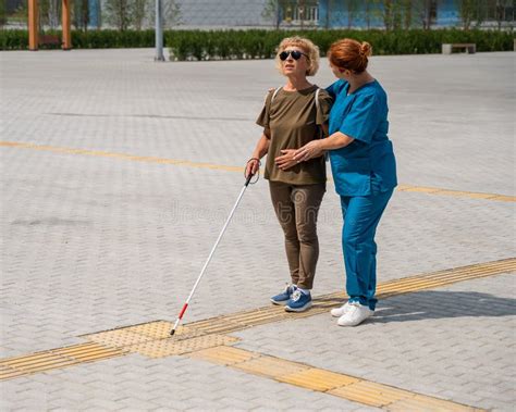 une personne aveugle jardinant avec l'aide d'outils adaptés