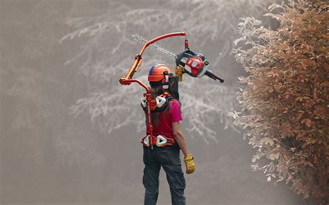 Vue d'un paysagiste utilisant un exosquelette Exhauss pour tailler une haie haute