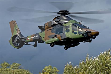 Image d'un hélicoptère militaire en vol au-dessus d'un paysage de campagne
