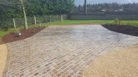 Exemple d'aménagement de jardinières intégrées dans une cour pavée