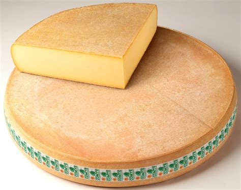 Photo macro d'une meule de Comté coupée, montrant la texture de la pâte et les cristaux de tyrosine, signes d'un long affinage