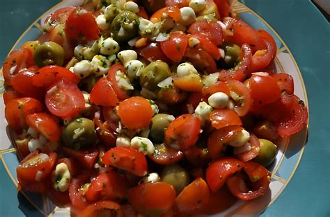 Un saladier rempli de tomates cerises multicolores sur une table de jardin en été