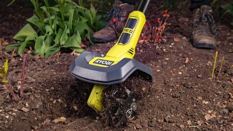 une personne utilisant une bineuse électrique dans un potager