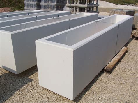 jardinière rectangulaire en béton gris sur une terrasse moderne