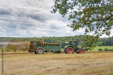 Champ agricole avec tracteur épandant du fumier