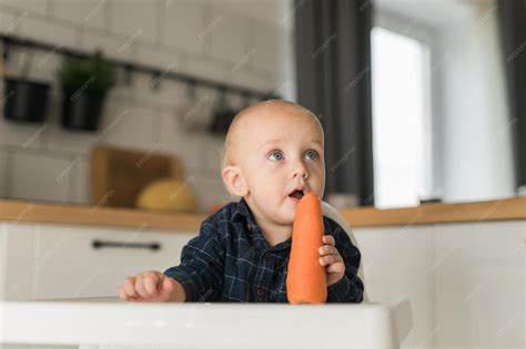 Bébé mangeant son premier petit pot de carottes
