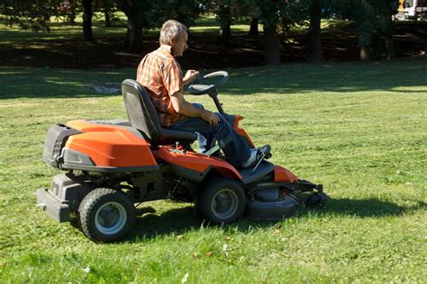 agriculteur sur tracteur tondeuse entretenant une vaste pelouse