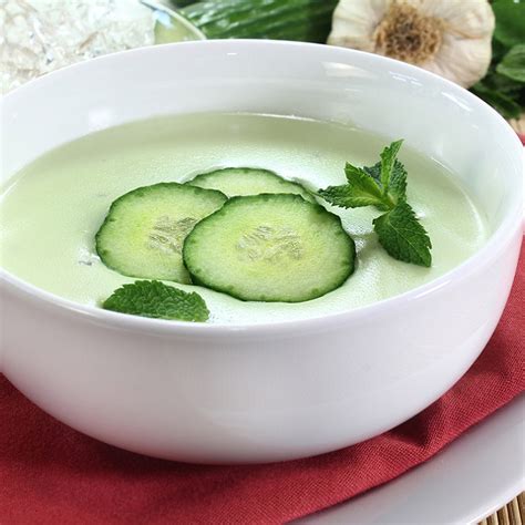Plateau de présentation avec bols de soupe au concombre et ingrédients frais