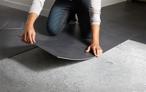 Installation de dalles PVC adhésives sur un sol carrelé