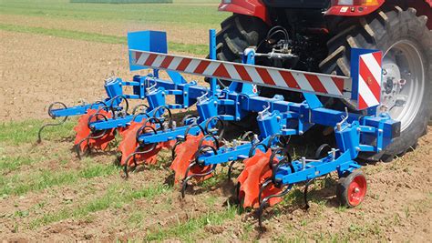 Schéma technique d'une bineuse agricole montrant les éléments bineurs et les socs en action sur l'inter-rang