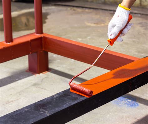 Application de peinture au rouleau sur une rambarde métallique