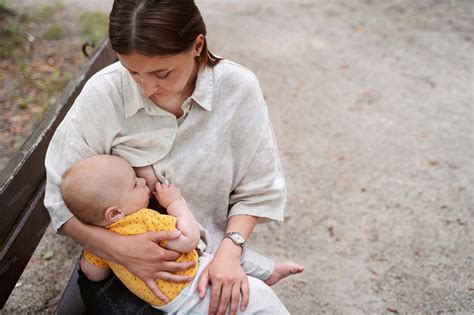 Mère allaitant son bébé avec une tisane à proximité