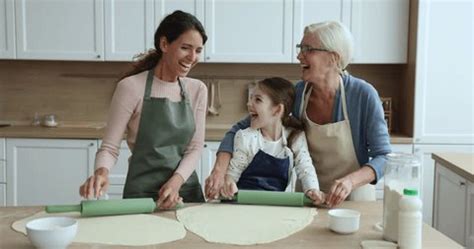 enfant et grand-mère préparant une tarte avec des fruits du jardin