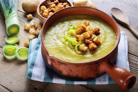 une assiette de potage Saint-Germain fumant avec des lardons grillés en garniture