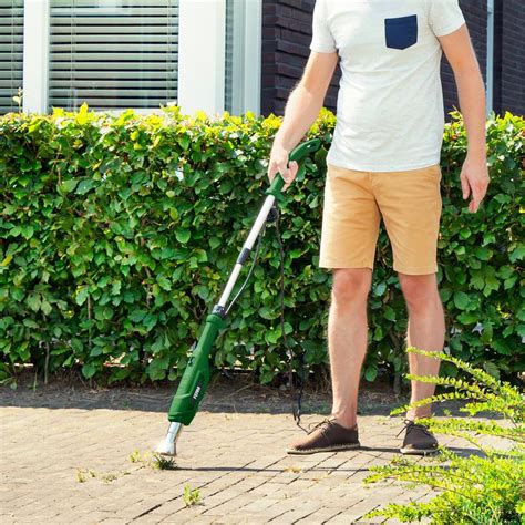 Désherbeur thermique en action sur une allée pavée