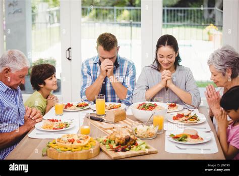 Famille priant avant le repas