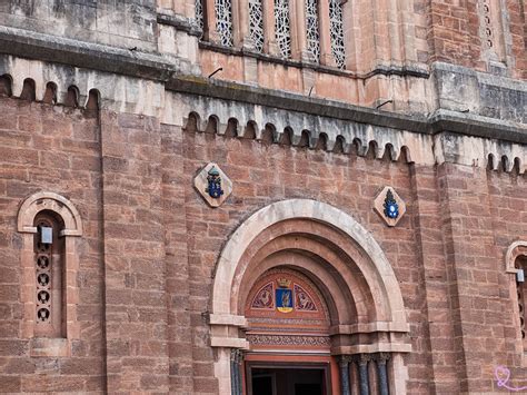 Détail architectural du grès rose de l'abbaye entouré de massifs de fleurs
