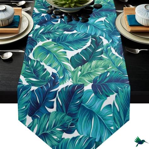 Table décorée avec chemin de table tropical et sets de table en forme de feuille de palmier