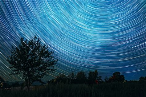 Photo de longue exposition montrant un filé d'étoiles au-dessus d'un paysage nocturne