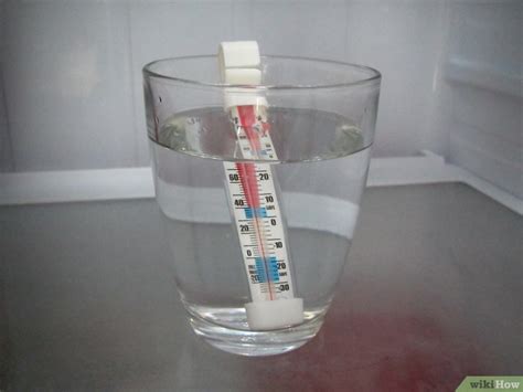 Thermomètre dans un verre d'eau pour vérifier la température du réfrigérateur