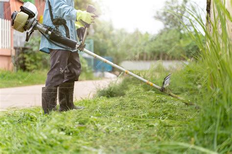 Un jardinier utilisant une débroussailleuse dans un jardin bien entretenu