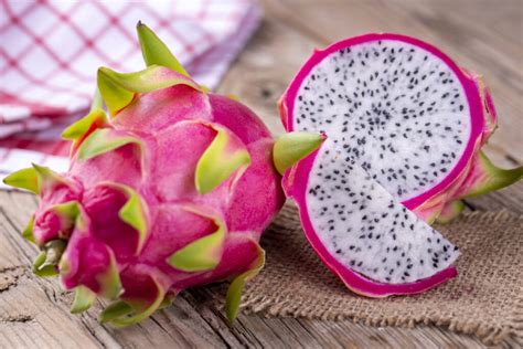 Photographie en coupe d'un fruit du dragon, révélant la chair blanche parsemée de graines noires