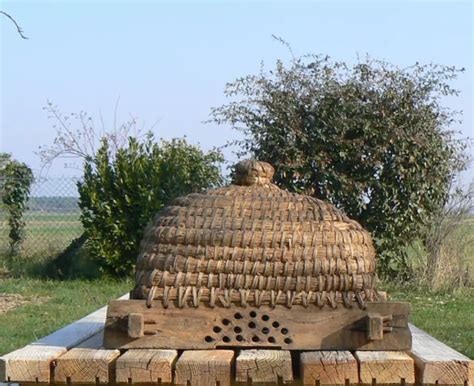 Intérieur du musée de l'apiculture avec une ancienne ruche en paille et outils historiques