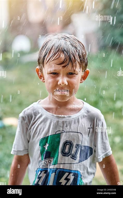 femme souriante en t-shirt mouillé sous la pluie